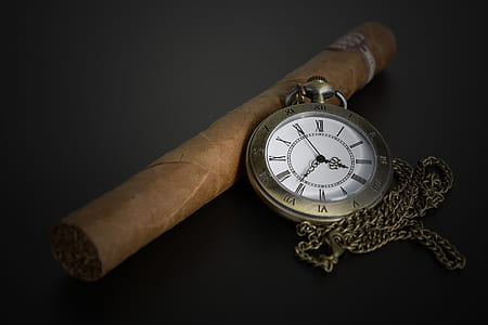 round brass-colored locket watch near brown tobacco thumbnail
