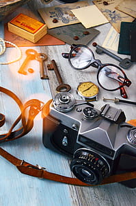 Black and Gray Camera, Skeleton Keys, and Brown Framed Eyeglasses on Gray Surface thumbnail