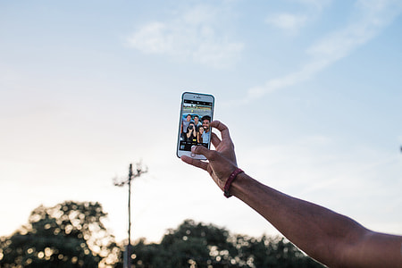 A man taking a selfie with his iPhone mobile smartphone thumbnail