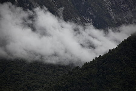 green mountains with white smokes during daytime thumbnail
