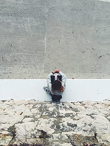 woman in gray hoodie and black bottom sitting on concrete pavement outdoors thumbnail