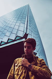 man standing in front of high rise building during daytime thumbnail
