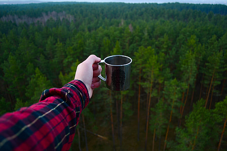 person holding gray stainless steel mug thumbnail