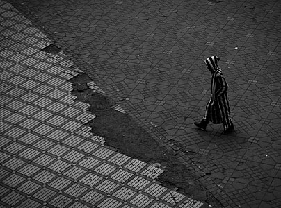 photo of man wearing black and white striped clothes walking thumbnail