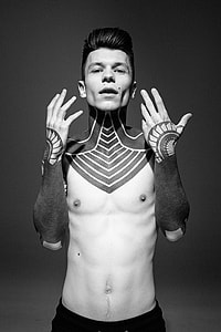 grayscale photo of man with neck and arm tattoos thumbnail