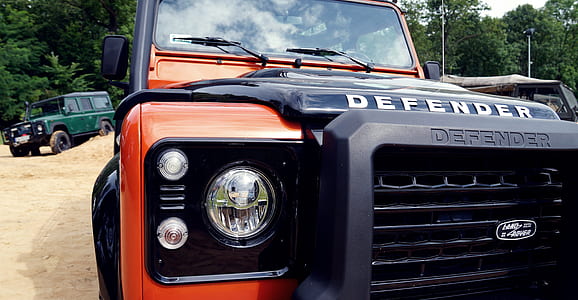 closeup photo of orange and black Land Rover Defender SUV thumbnail