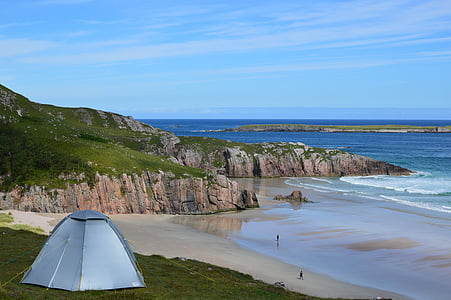 gray dome tent on green grass near sea thumbnail