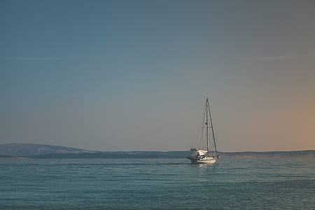 White Sailboat on Body of Water Under White Sky thumbnail