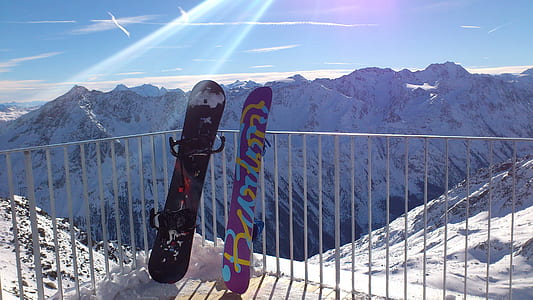 two snowboards leaning on fence thumbnail