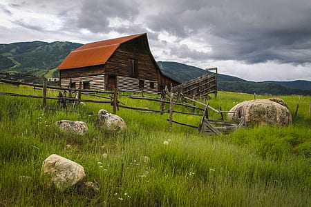 brown and grey wooden barn house in the middle of fields thumbnail