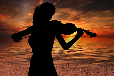 silhouette photography of woman plying piano thumbnail