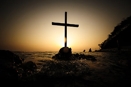 silhouette photo of cross in the middle of ocean thumbnail