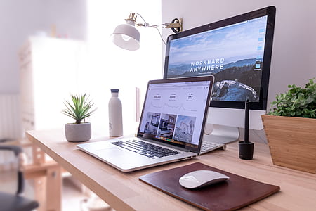 MacBook Pro near silver iMac on top of desk thumbnail