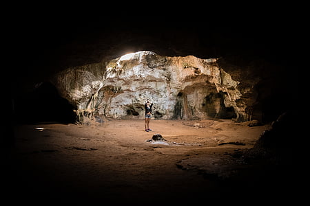 person standing at center of cave thumbnail