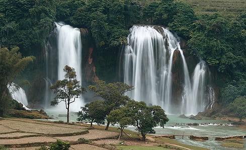 waterfalls surrounded by trees during daytime thumbnail