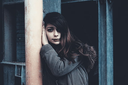 woman wearing jacket resting head on post thumbnail