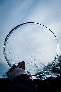 person holding round clear glass panel thumbnail