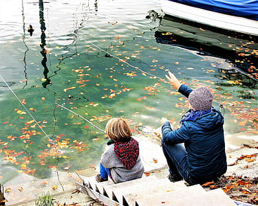 boy and man fishing while sitting on concrete stairs thumbnail
