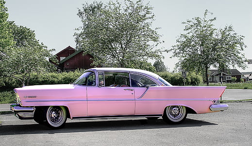 classic pink coupe on road near trees during daytime thumbnail