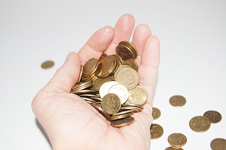 person holding round gold-colored coins thumbnail
