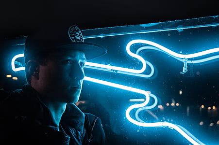 Man In Black Jacket Beside Blue Neon Light Guitar thumbnail