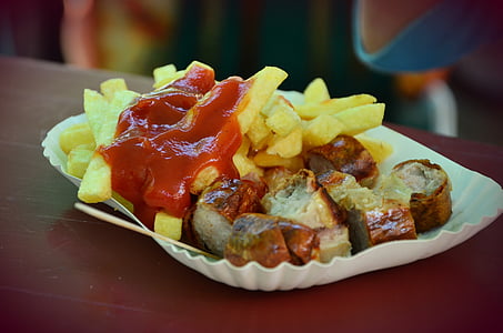 roasted meat and fries with tomato sauce in white plate on brown wooden table thumbnail