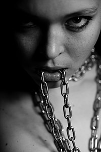 grayscale photo of woman biting chain thumbnail