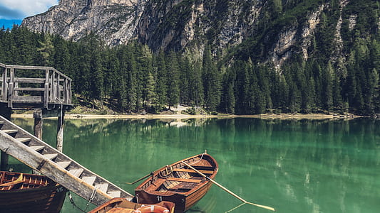 brown canoe boat on body of water near brown wooden dock at daytime thumbnail