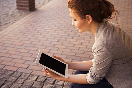 woman holding white tablet computer thumbnail
