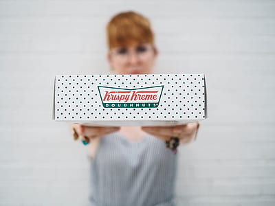person holding Krispy Kreme doughnuts box thumbnail