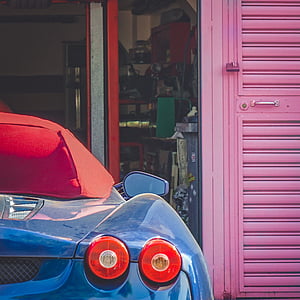 blue and red convertible parked near pink door thumbnail