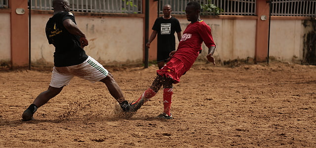 two men kicking ball at soccer match thumbnail