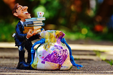 man wearing suit jacket carrying books near drawstring bag figurine thumbnail