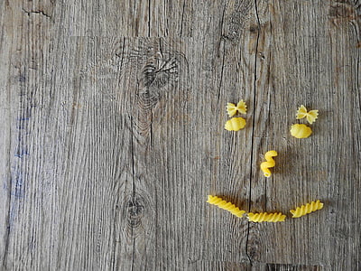 pasta forming face on brown wooden panel thumbnail