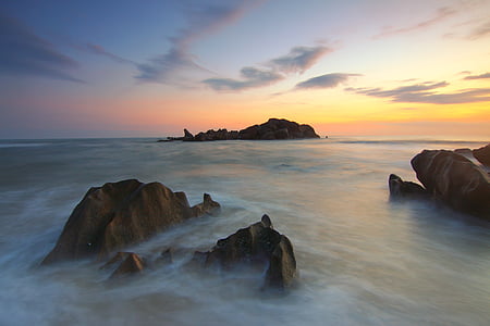 rock islands by ocean under blue sky thumbnail