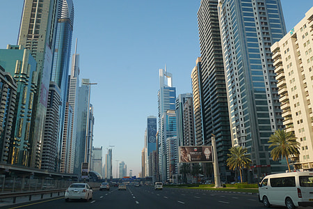 assorted-color vehicles on road between city buildings during daytime thumbnail