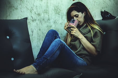 woman sitting on sofa while drinking thumbnail