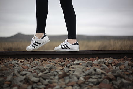 selective focus photo of woman standing on train rail thumbnail
