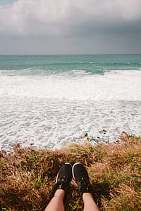 Person Wearing Pair of Black Running Shoes Near Body of Water thumbnail