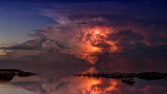 reflection of lightning on body of water during golden hour thumbnail