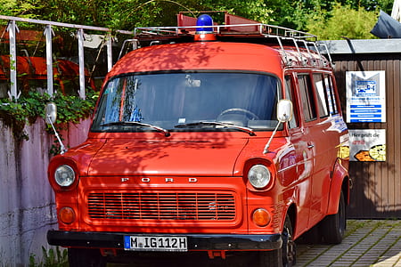 orange Ford van on pavement near wall thumbnail