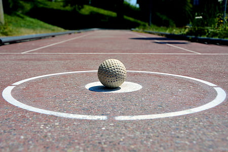 golf ball on brown asphalt road during daytime thumbnail