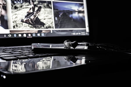black canal bud earphones on laptop thumbnail