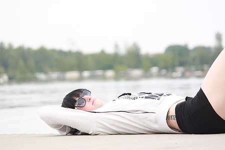 woman lying on concrete ground wearing white long sleeve shirt and black short shorts thumbnail