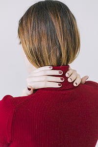 Woman in Red Turtle-neck Shirt Touching Her Neck thumbnail