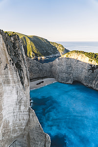 photo of body of water near mountain thumbnail