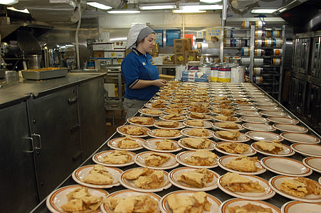 woman in blue polo shirt preparing the food on inline plates thumbnail