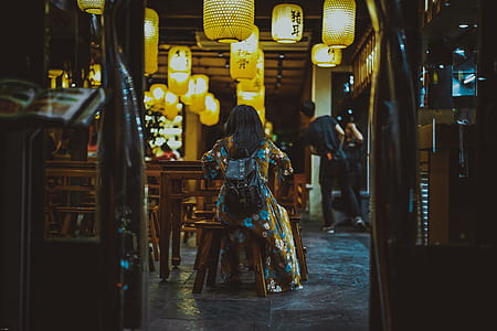 woman sitting on brown wooden chair thumbnail