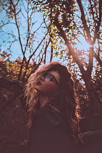woman in black frame clubmaster eyeglasses with trees background thumbnail