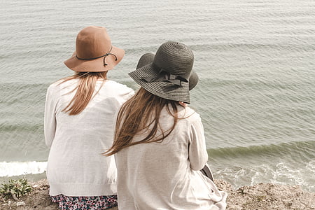 two women near water wearing hat and white top thumbnail